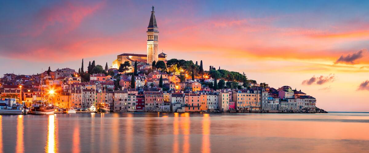 Fantastic spring sunset of Rovinj town, Croatian fishing port on the west coast of the Istrian peninsula. Colorful evening seascape of Adriatic Sea. Traveling concept background.
