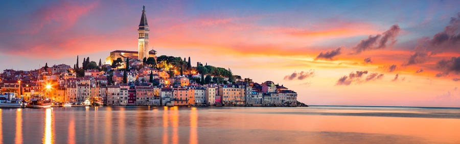 Fantastic spring sunset of Rovinj town, Croatian fishing port on the west coast of the Istrian peninsula. Colorful evening seascape of Adriatic Sea. Traveling concept background.