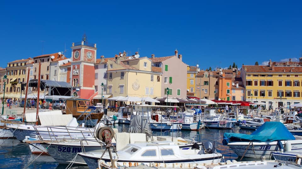 A marina with colorful buildings, boats, and a clock tower.