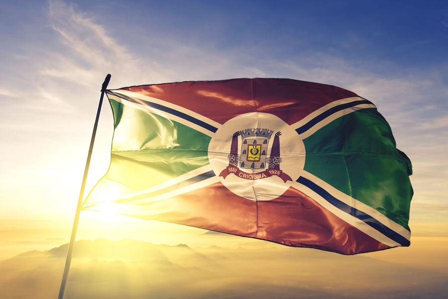 Criciuma of Brazil flag waving on the top sunrise mist fog