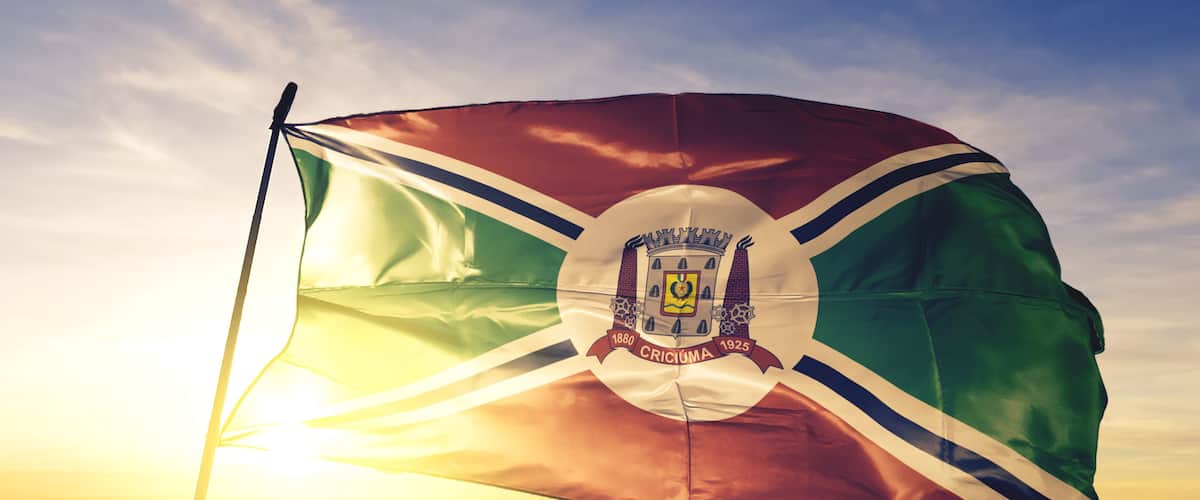 Criciuma of Brazil flag waving on the top sunrise mist fog