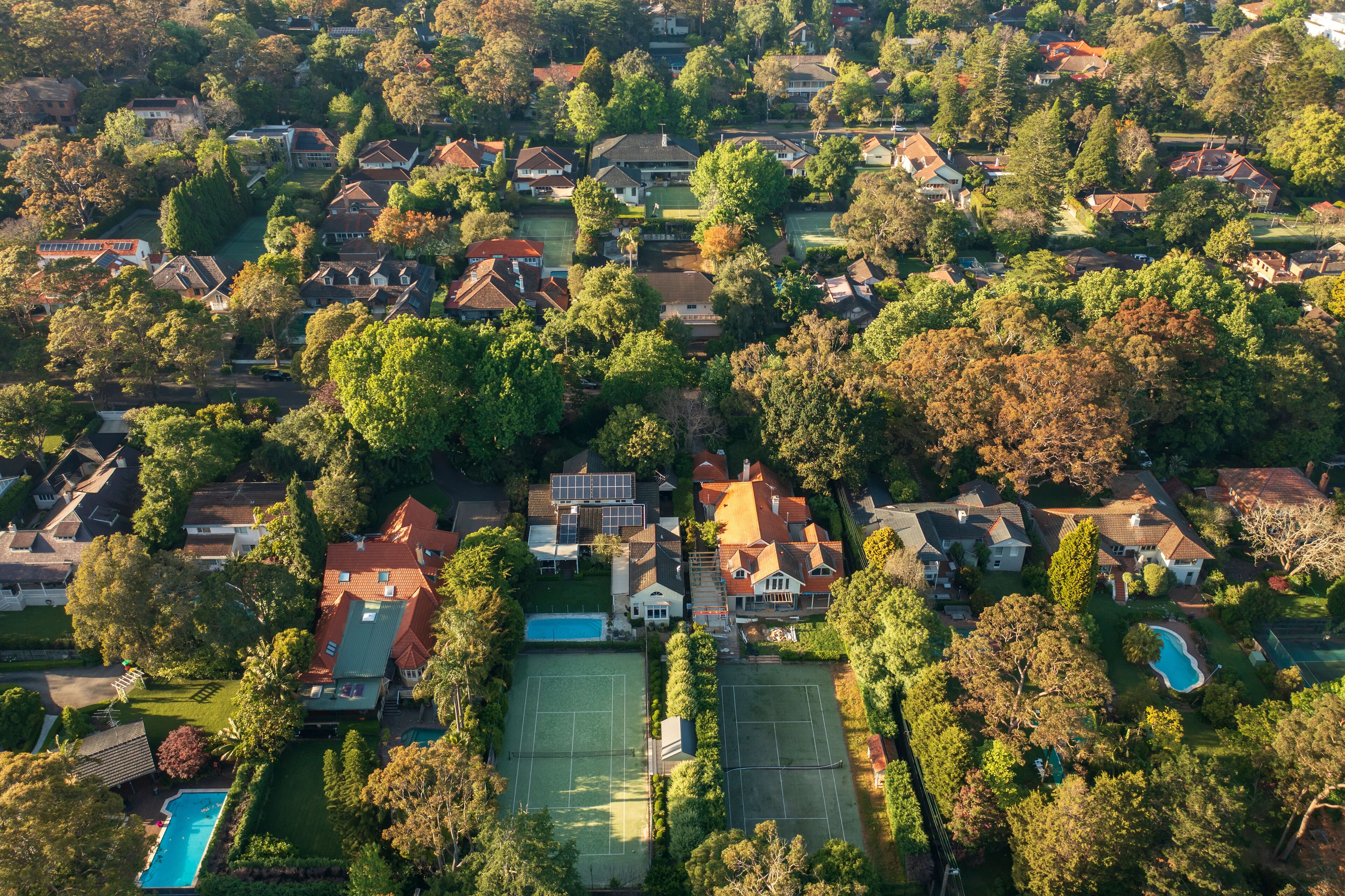 Aerial view of upmarket houses with private gardens, pools and tennis courts on Sydney&#x27;s leafy North Shore.