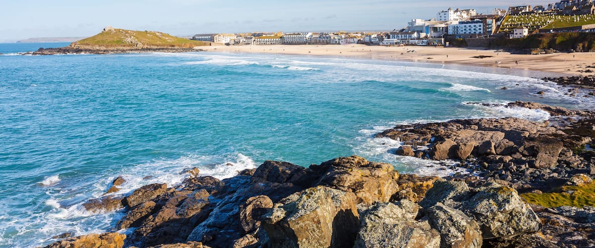 A coastal town with a rocky shoreline, a sandy beach, and buildings along the coast.