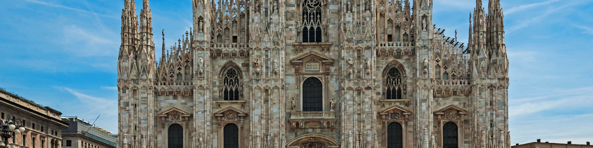 The Duomo of Milan seen from the Piazza, with tourists around on a typical summer day