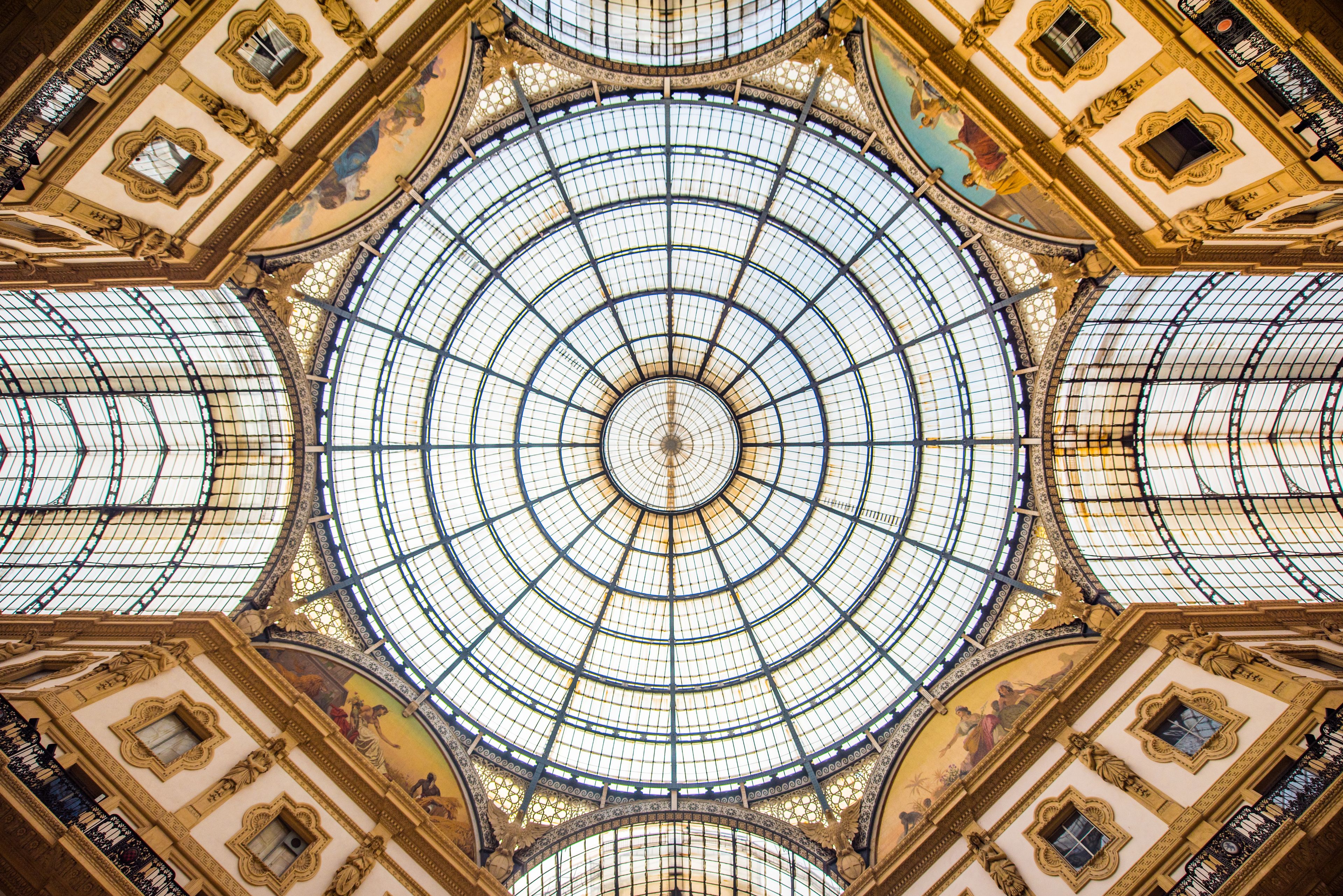 Uma grande cúpula de vidro ornamentada, com padrões intrincados e um desenho circular central.