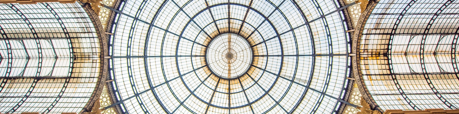 Uma grande cúpula de vidro ornamentada, com padrões intrincados e um desenho circular central.