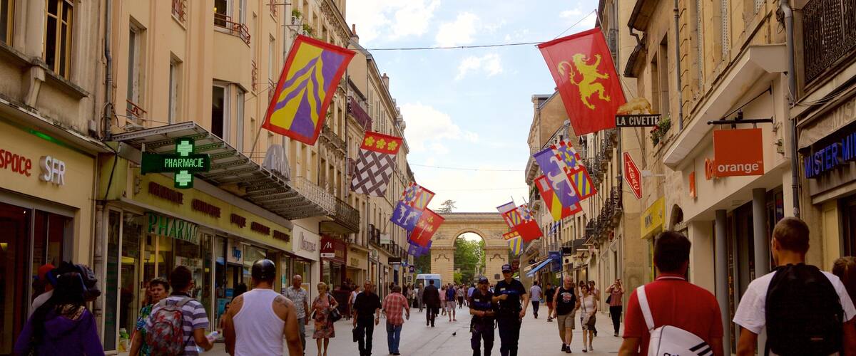 A bustling street lined with shops and cafes, adorned with colorful flags and banners.