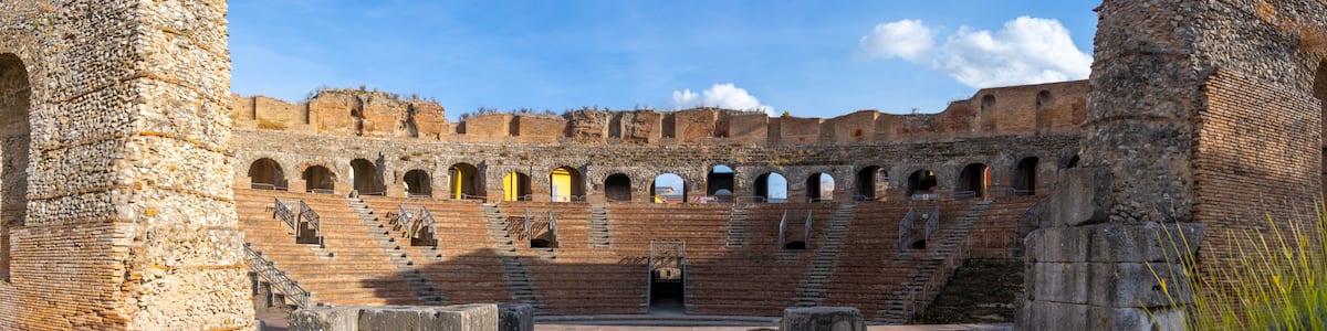 An ancient amphitheater with stone steps and a central stage.
