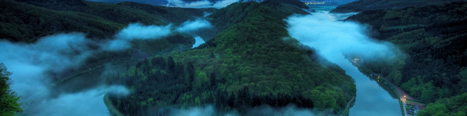 Please take a large view! Die Saarschleife, Durchbruchstal der Saar durch den Taunusquarzit, gehört zu den bekanntesten Sehenswürdigkeiten des Saarlandes. Die schönste Ansicht bietet der Aussichtspunkt Cloef im Mettlacher Ortsteil Orscholz, 180 m hoch über dem Fluss. Auch unmittelbar vom Saarufer aus bieten sich imposante Ausblicke. Steil zerklüftete Felswände wechseln mit Schutthalden und kleinen Schluchten ab. Die Saarschleife beginnt kurz hinter Merzig beim Stadtteil Besseringen und endet in Mettlach. Die Luftlinie zwischen Besseringen und Mettlach beträgt nur etwa zwei Kilometer. Die Saar macht einen romantischen "Umweg", der nahezu zehn Kilometer beträgt. Auf dem bewaldeten Bergrücken innerhalb der Saarschleife befinden sich die Kirche St. Gangolf mit Teilen der ehemaligen Klosteranlage und die Burgruine Montclair. Einziger Ort in der Saarschleife ist das Dorf Dreisbach (Saar), wo man mit einer Fähre übersetzen kann. Die Saarschleife gilt als das Wahrzeichen des Saarlandes. Ins Rampenlicht rückte sie immer wieder, wenn Staatsoberhäupter sich dort einfanden: Friedrich Wilhelm IV., König von Preußen besuchte den Aussichtspunkt Cloef mit Blick auf die Saarschleife am 29. September 1856. Der "Führer und Reichskanzler" Adolf Hitler besichtigte sie am 16. Mai 1939. Der Bundeskanzler Konrad Adenauer traf sich dort am 25. Juni 1965 mit saarländischen Politikern. Oskar Lafontaine und Gerhard Schröder wurden am 4. August 1997 an der Cloef mediengerecht mit der Saarschleife ins Bild gesetzt. Der französische Präsident Jacques Chirac und der polnische Präsident Lech Kaczynski trafen sich an der Saarschleife zum Dreiergipfel mit Bundeskanzlerin Angela Merkel am 5. Dezember 2006. From Wikipedia, the free encyclopedia