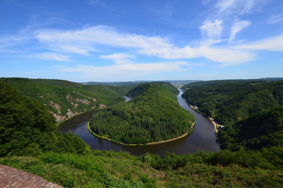 A river winding through a forested valley with hills on either side.