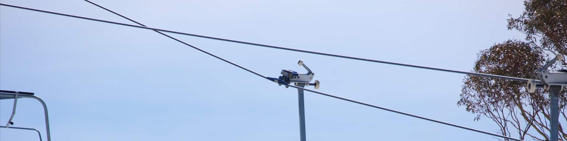 Snowy Mountains featuring a gondola and mountains as well as a family