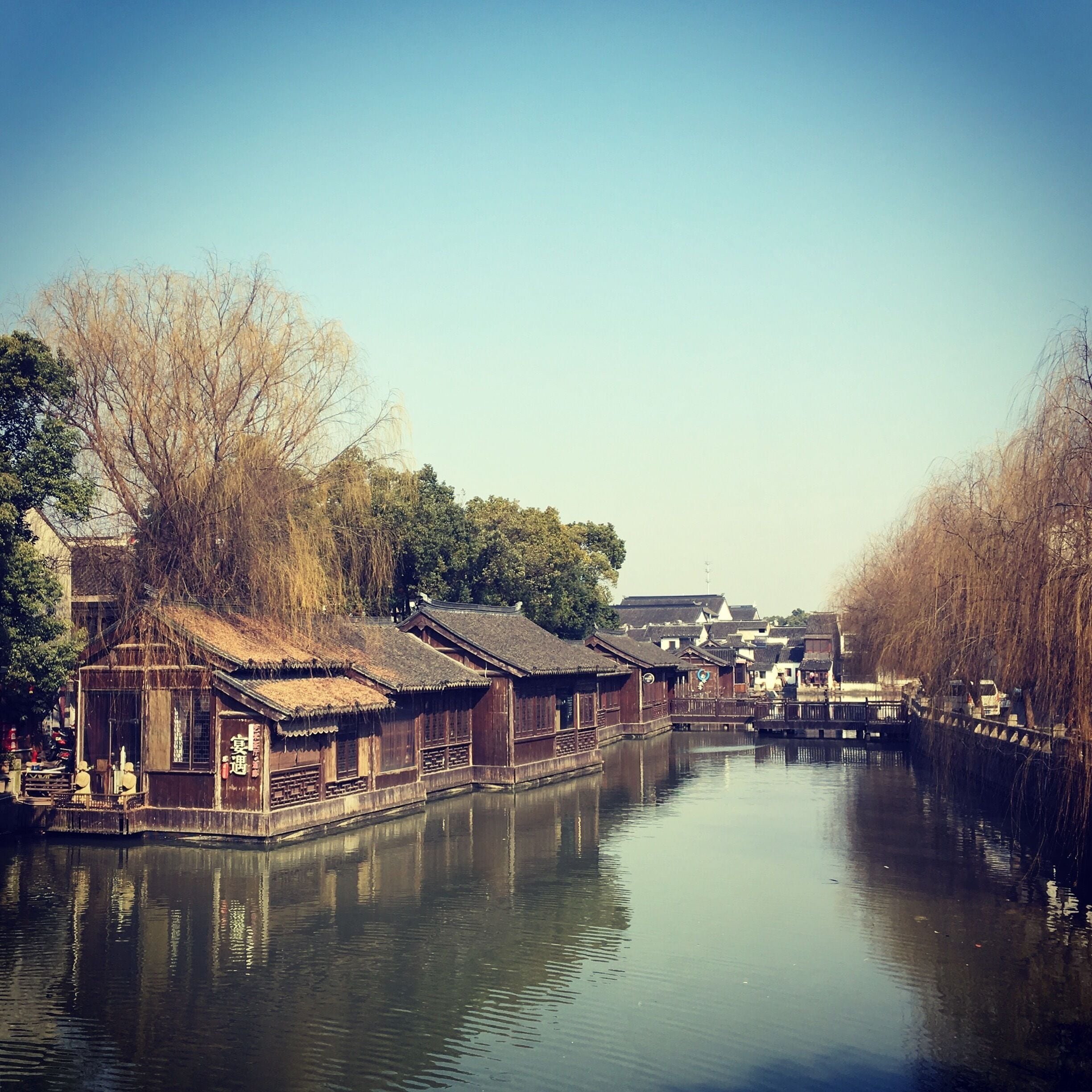 A calm river with traditional wooden houses on stilts along the banks.