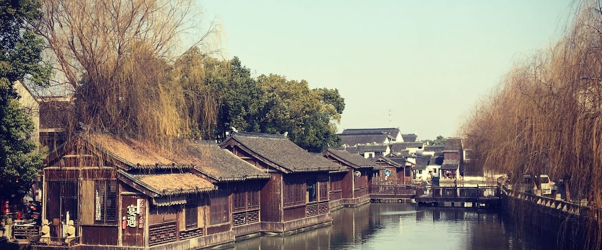 A calm river with traditional wooden houses on stilts along the banks.