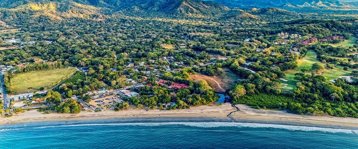 A coastal town with a beach, mountains, and a golf course.