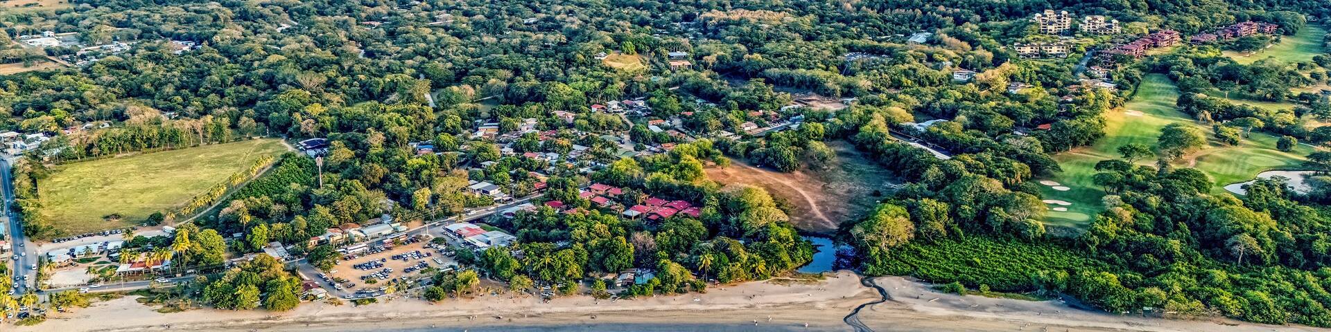 A coastal town with a beach, mountains, and a golf course.