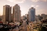 A cityscape with tall buildings, a busy street, and a clear sky.