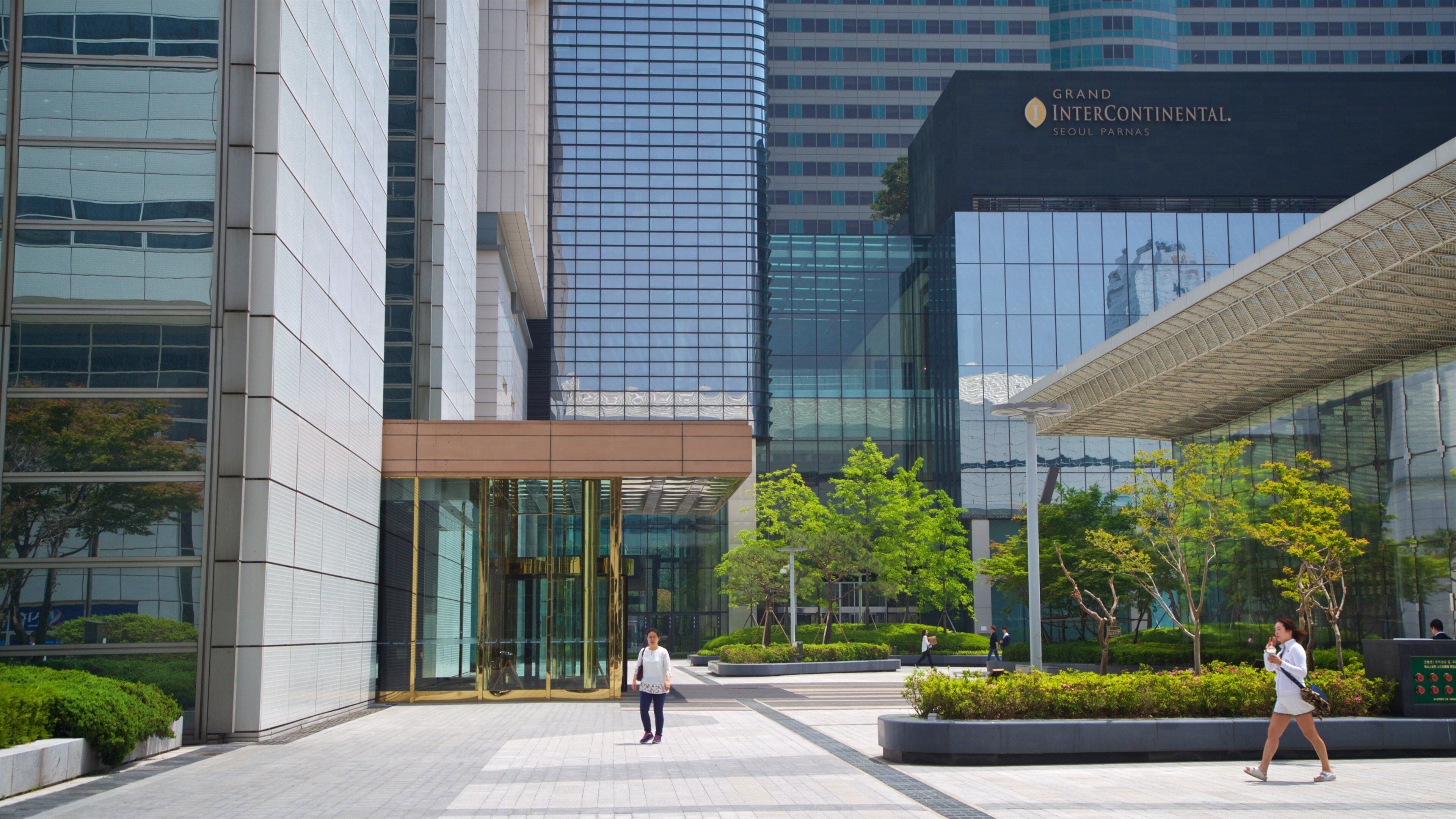 Een modern gebouw met glazen gevels en een bord waarop staat: Grand Intercontinental Seoul Parnas.