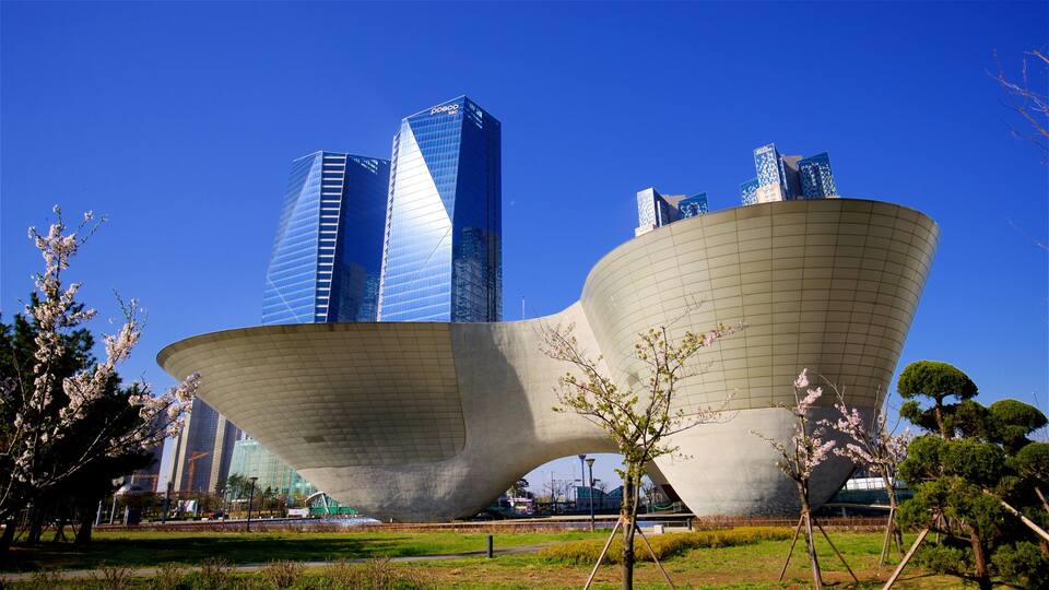 A modern sculpture in a park with skyscrapers in the background.