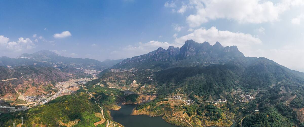 A mountainous landscape with terraced fields and a river.