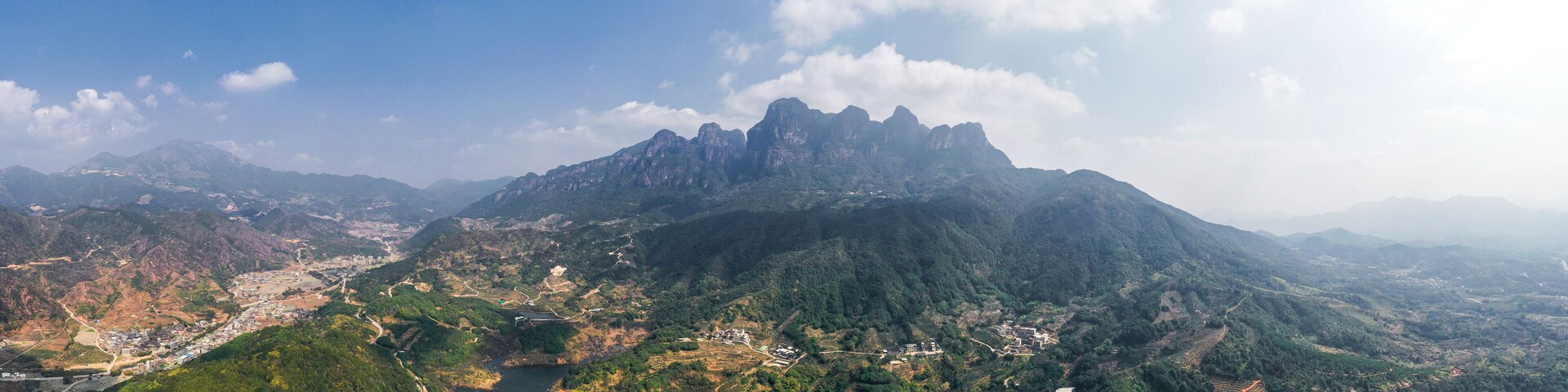 A mountainous landscape with terraced fields and a river.