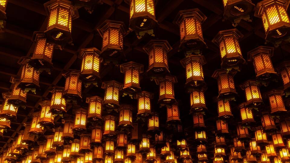 A dense array of traditional lanterns with intricate patterns, suspended from a ceiling.