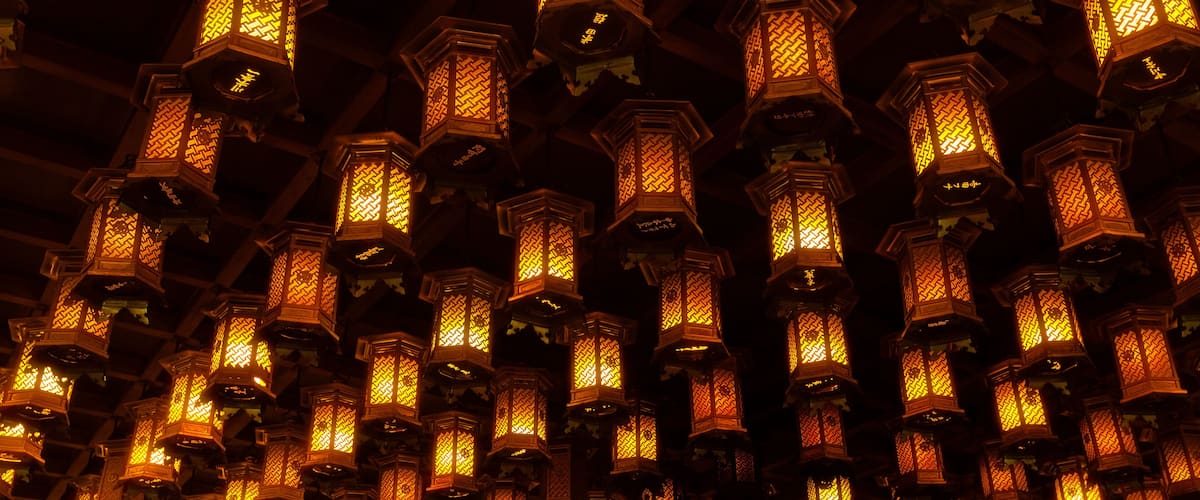 A dense array of traditional lanterns with intricate patterns, suspended from a ceiling.
