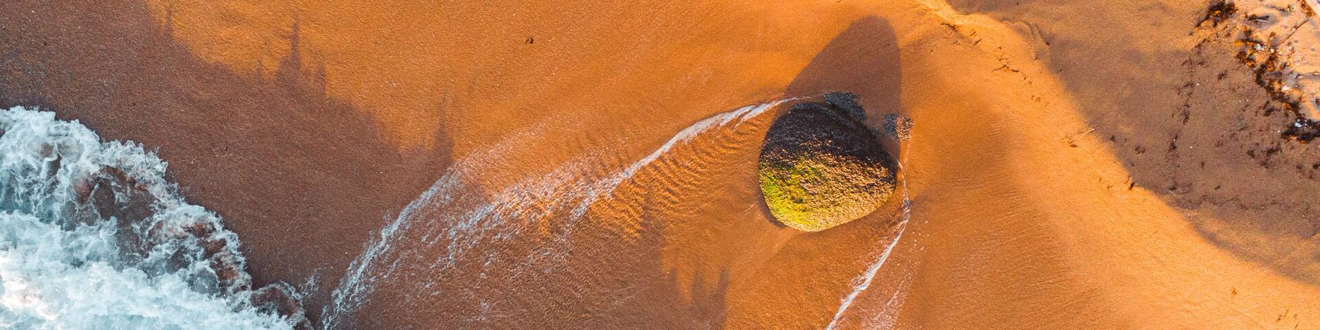 A sandy beach with waves crashing onto the shore.