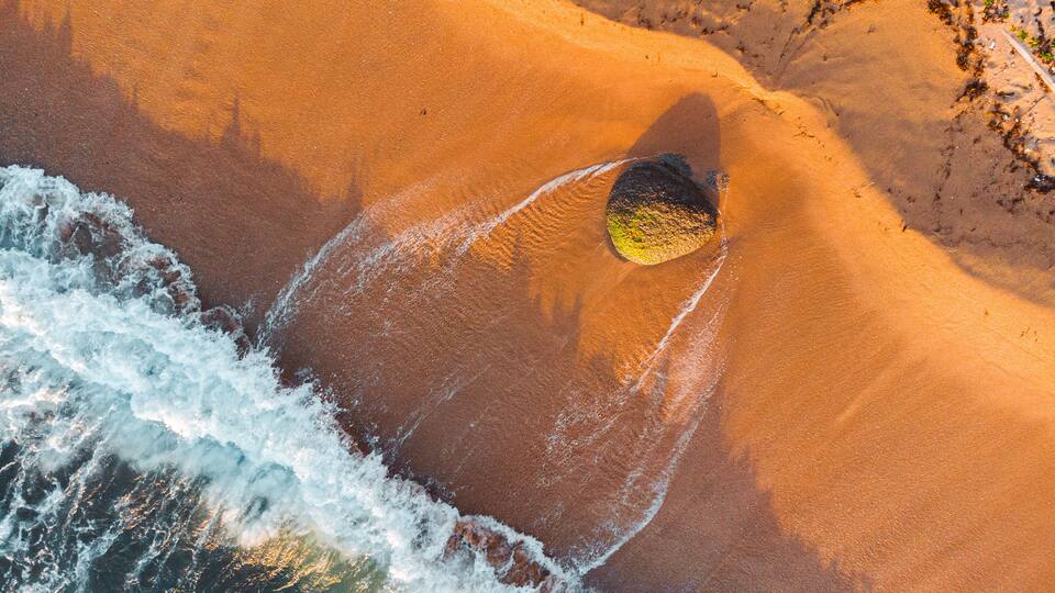 A sandy beach with waves crashing onto the shore.