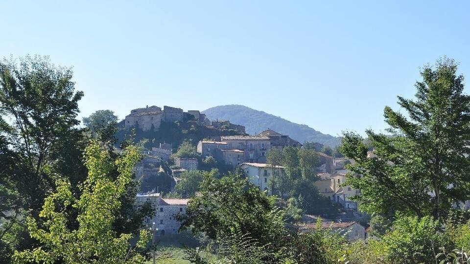 A hillside village with historic buildings and a prominent castle-like structure.