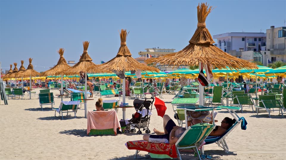 Torre Pedrera featuring a sandy beach and general coastal views as well as a small group of people