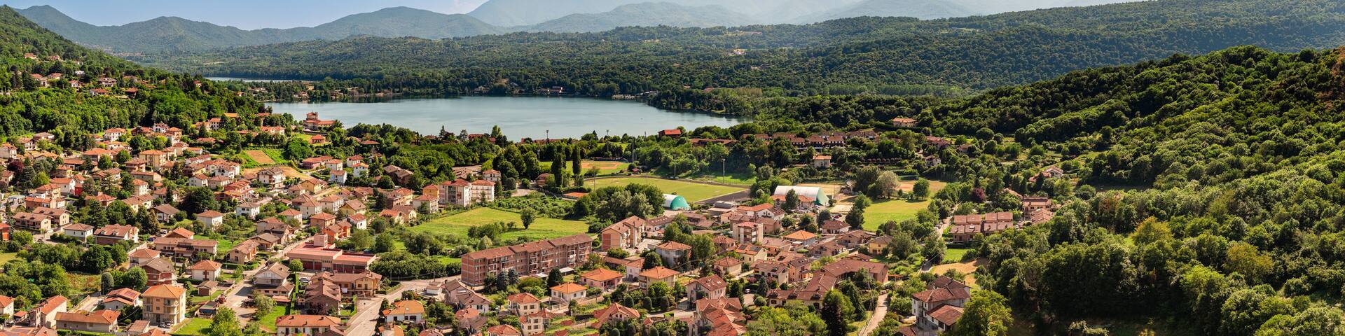 Aerial panoramic view of Avigliana end lake Grande, Italy, Piedmont, Turin, Italy A beautiful town with and red-roofed houses, surrounded by the green hills of Susa and trees.italian lakes