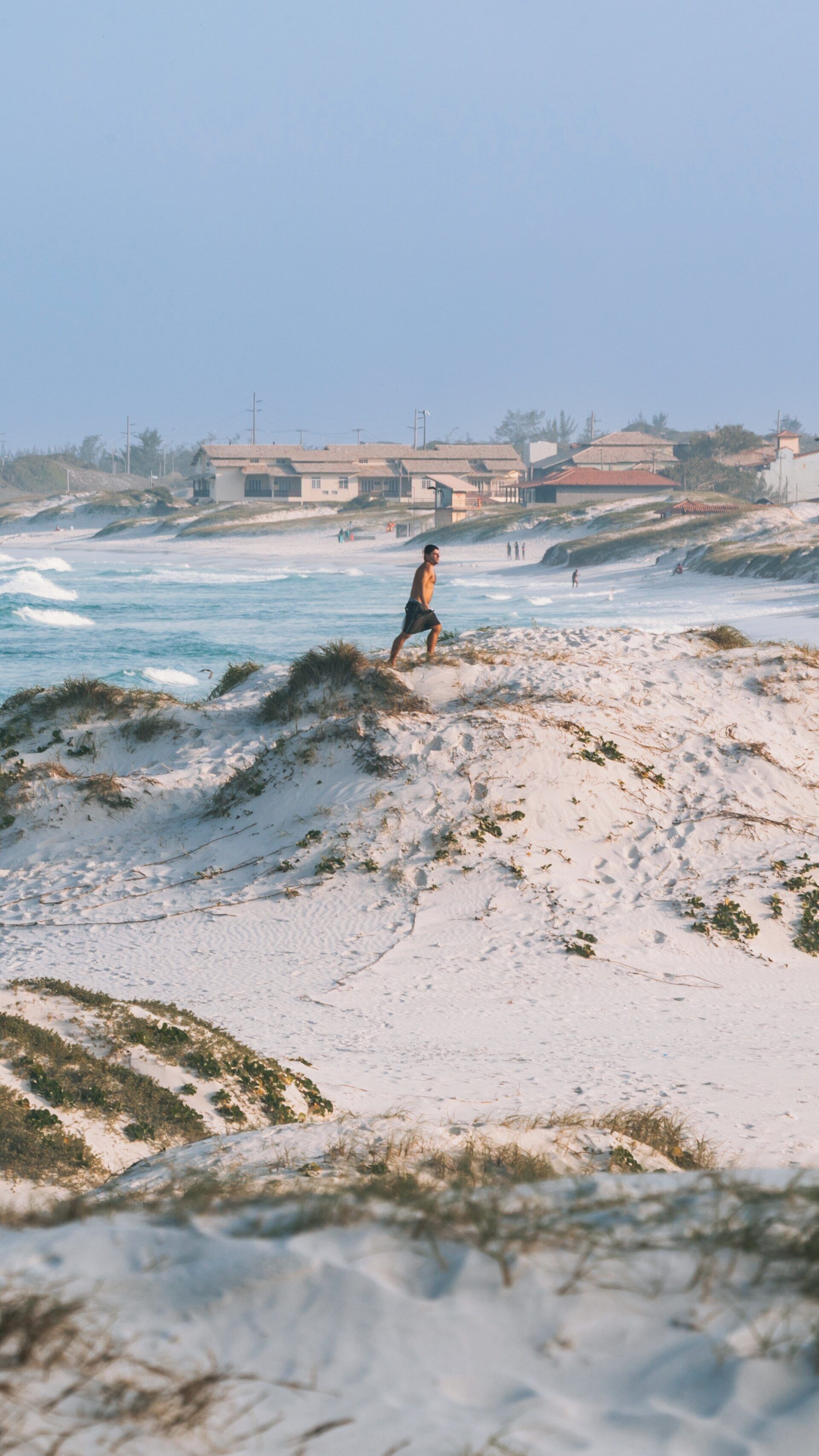 Exploring the serene beauty of Dunas Beach in Algodoal, Buzios, Rio de Janeiro, with gentle waves and sandy dunes at sunset