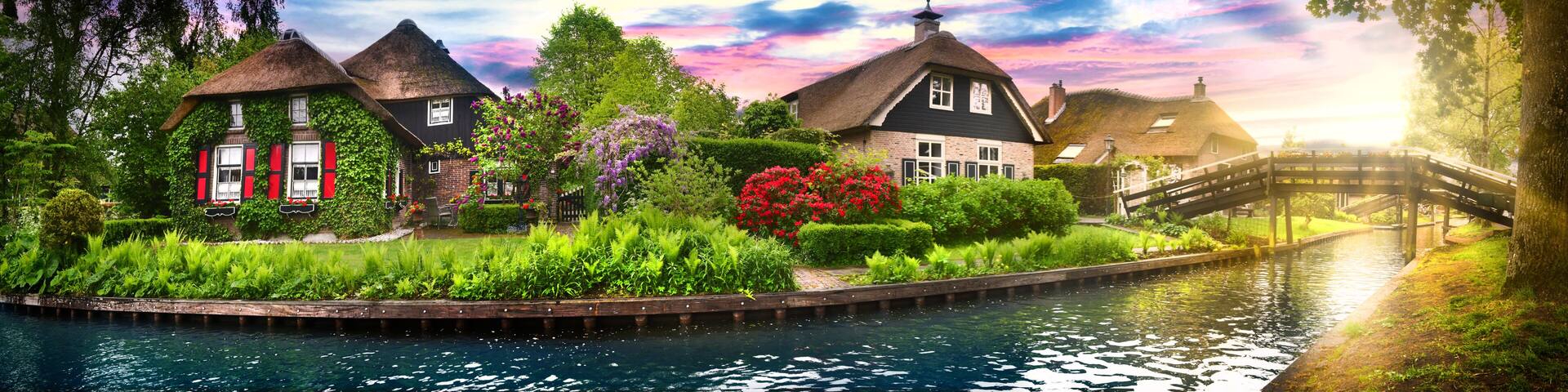 Landscape of Giethoorn village with water canals and rustic houses in netherland wide banner or panorama.