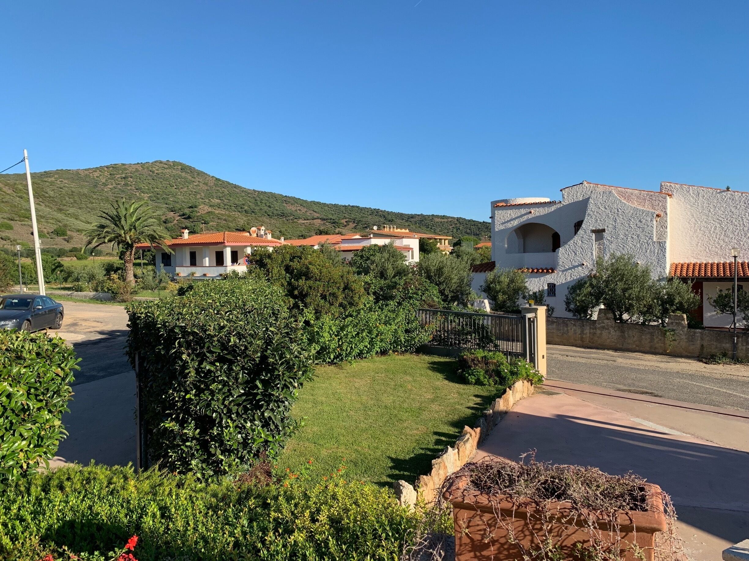 A residential area with houses, a road, and a hilly landscape.