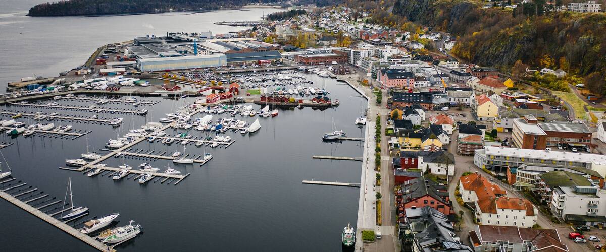 A harbor with boats, a marina, and buildings along the waterfront.