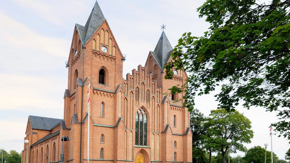 A large brick church with pointed towers and a prominent arched entrance.