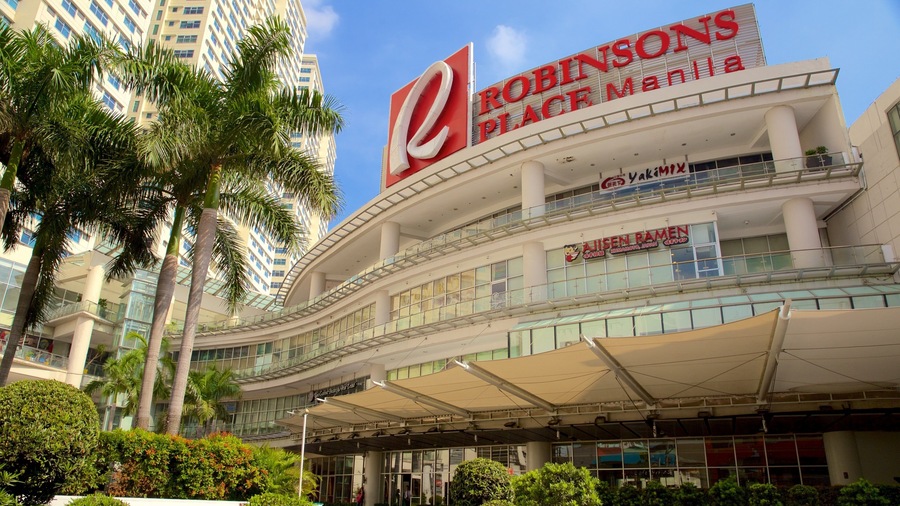 Robinsons Place Manila with a large 'R' sign, a modern building facade, and surrounding palm trees.