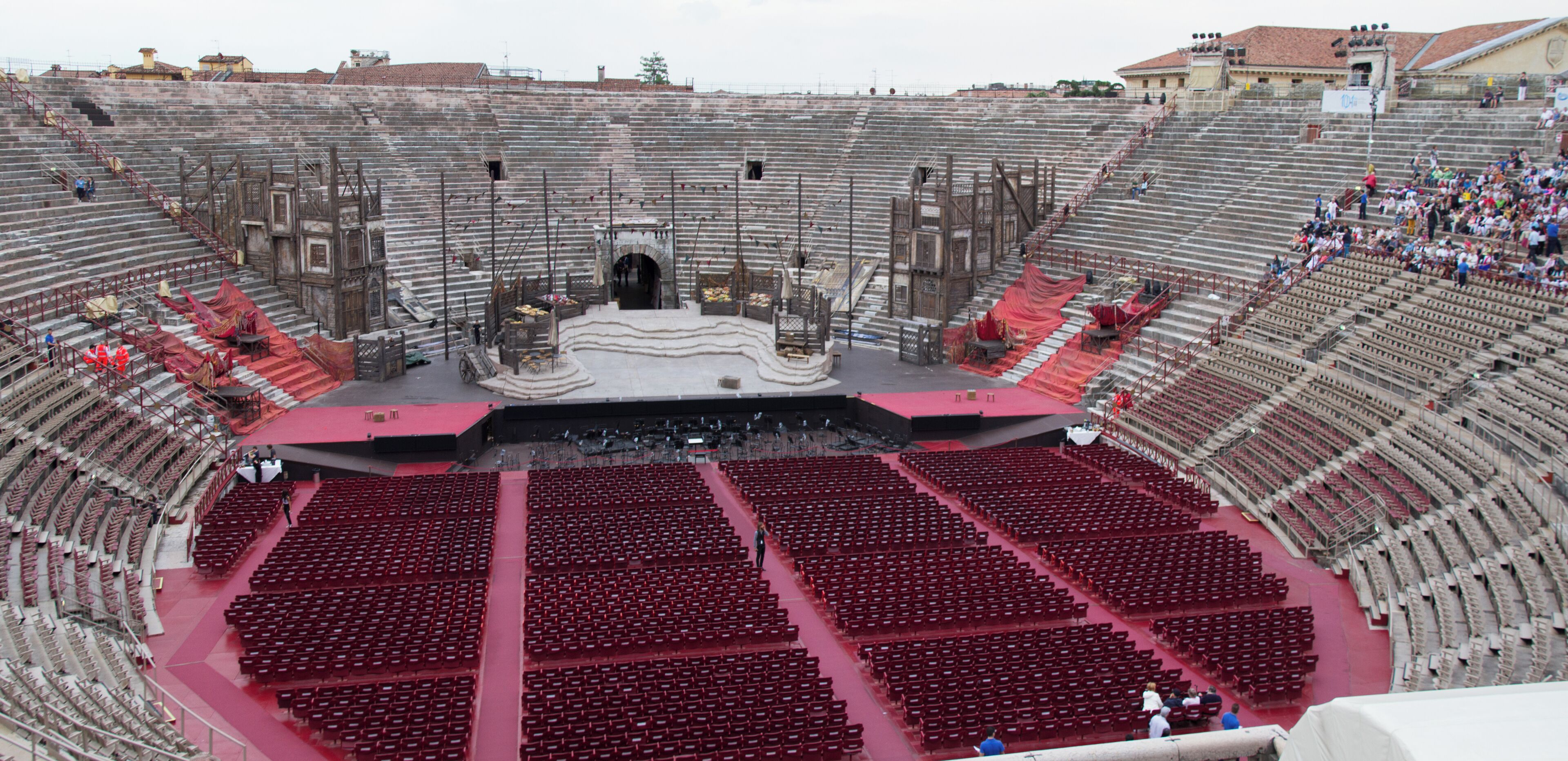 An ancient amphitheater with tiered seating and a central stage.