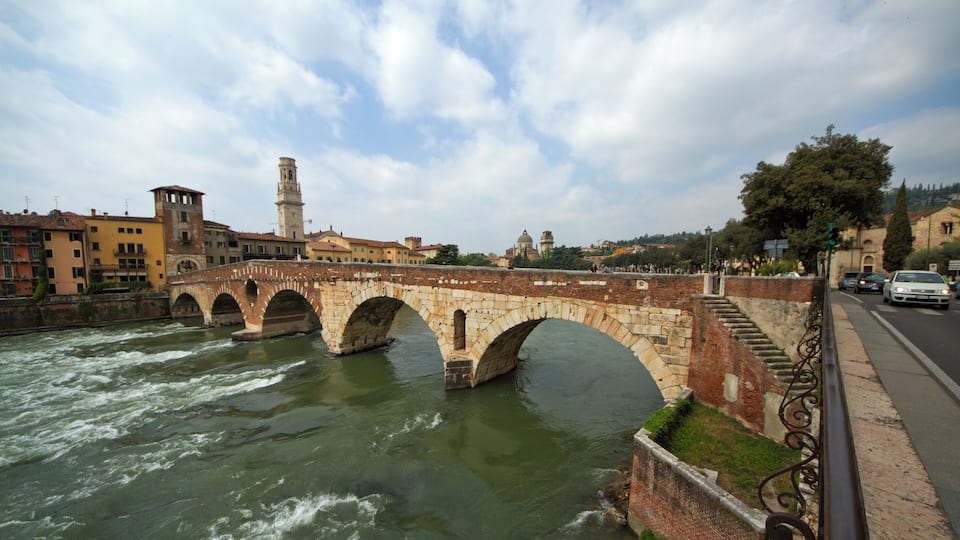 Un pont de pierre enjambant une rivière, avec une vue sur la ville en arrière-plan.