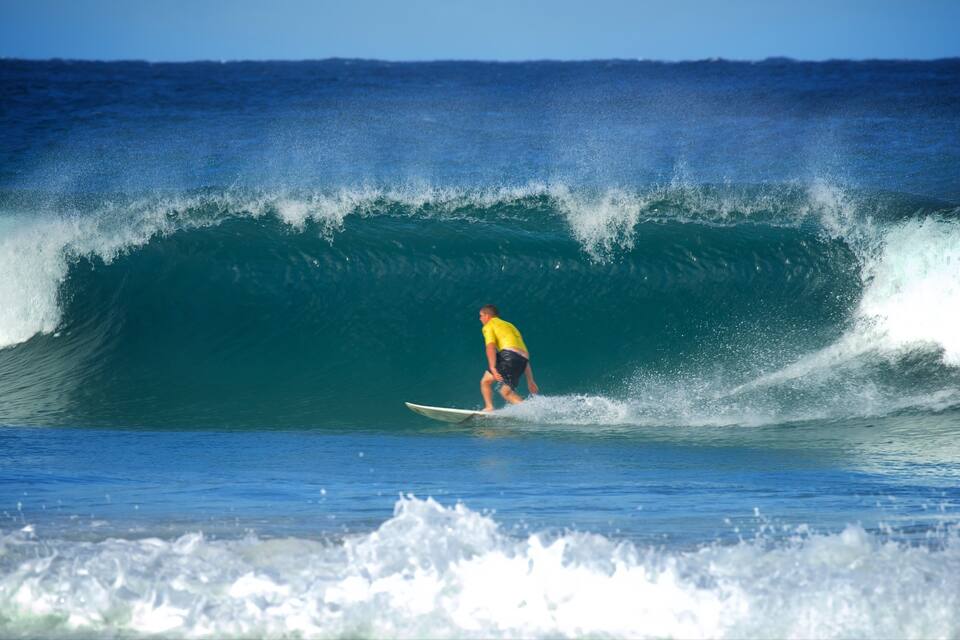 A surfer riding a large wave in the ocean.