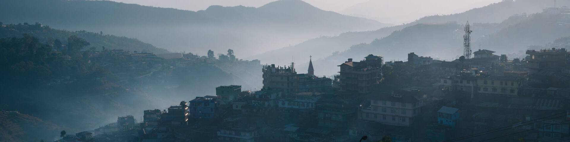 Sunrise over the hillside town of Kohima in Nagaland in India. Moody shot with early morning fog or mist