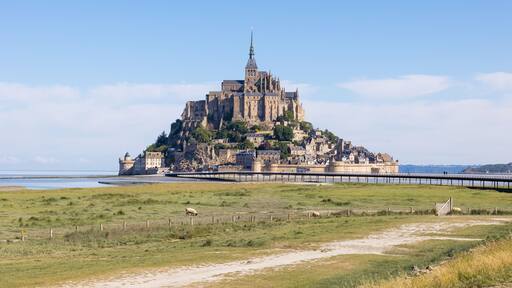 Vue sur le Mont Saint-Michel devant un pâturage des prés salés et ses agneaux