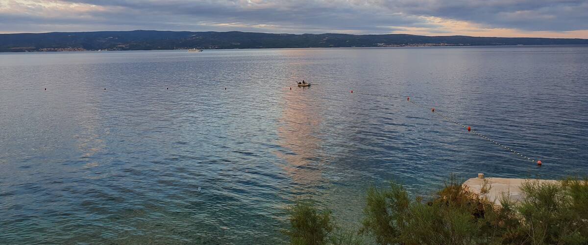 A calm lake with a clear sky and distant hills.