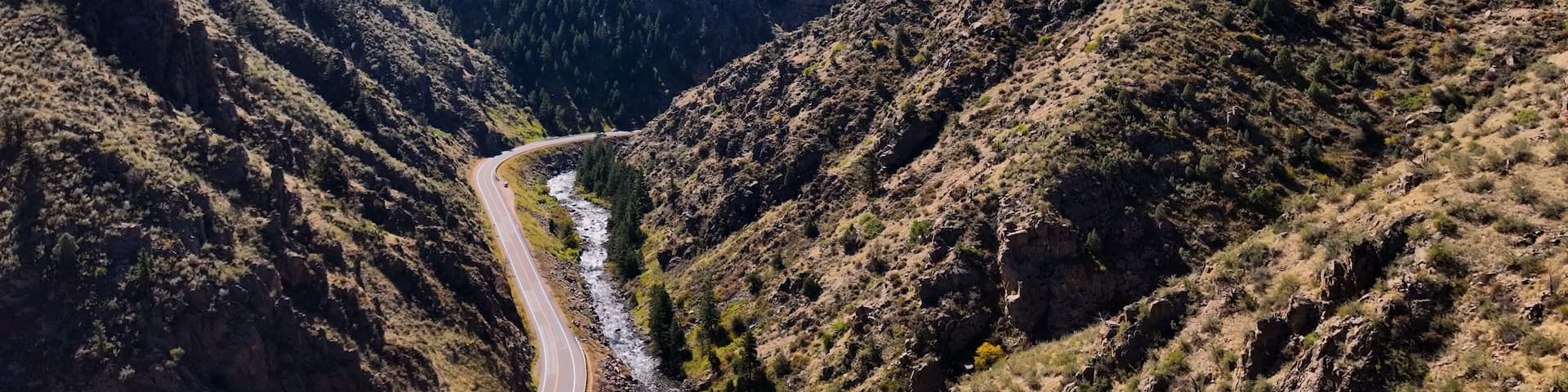 Aerial drone photo in the Colorado mountains of beautiful skies and winding highway. Clear view of distant hills colorful sky near Black Hawk.