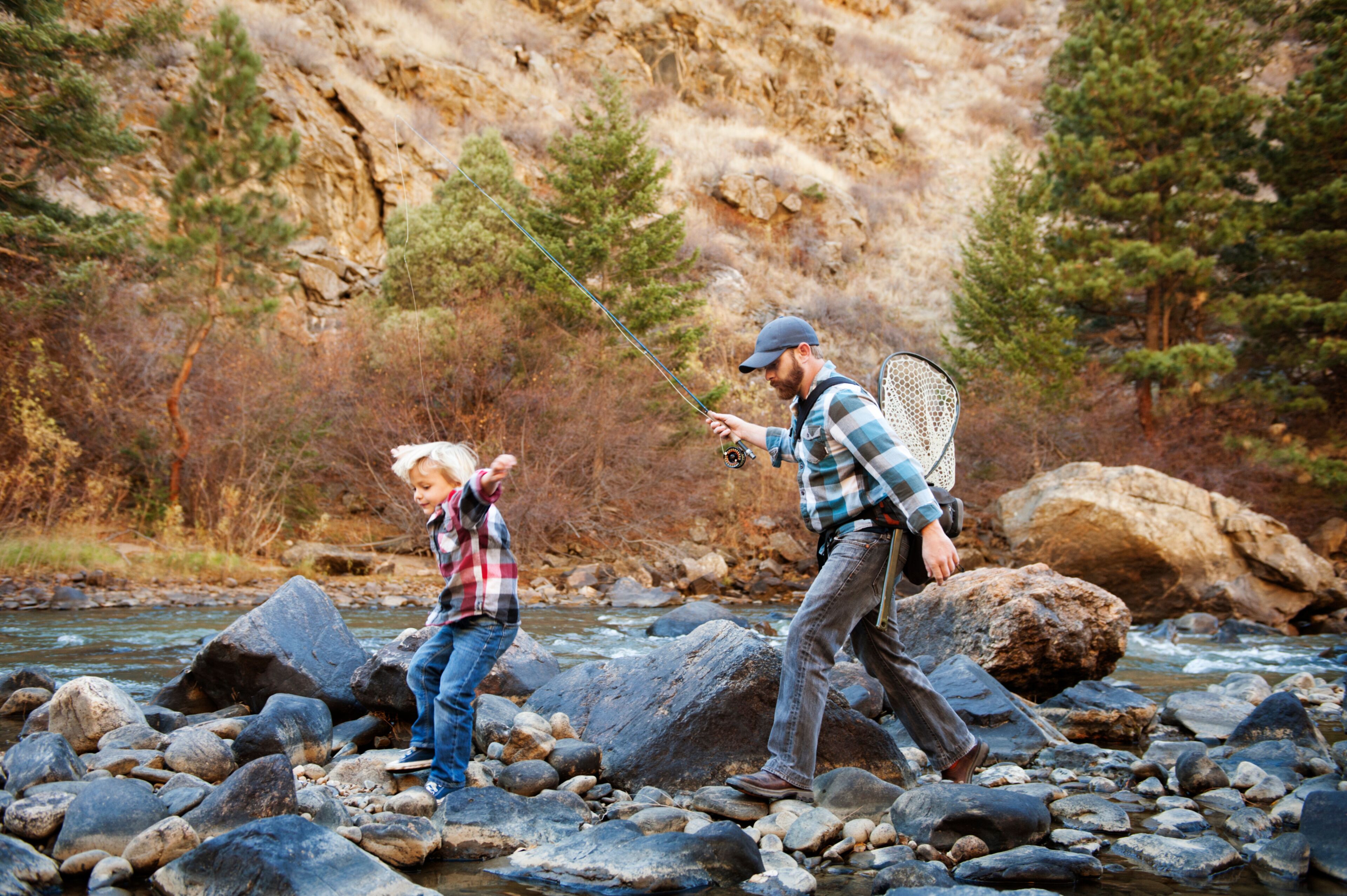 Father and son fishing in stream 