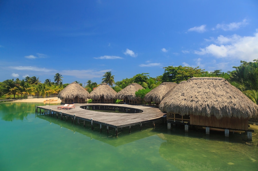 Stilted waterfront chalets and boardwalk, St. Georges Caye, Belize, Central America