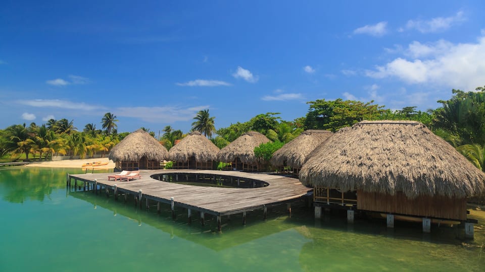 A tropical resort with overwater bungalows and a wooden dock.