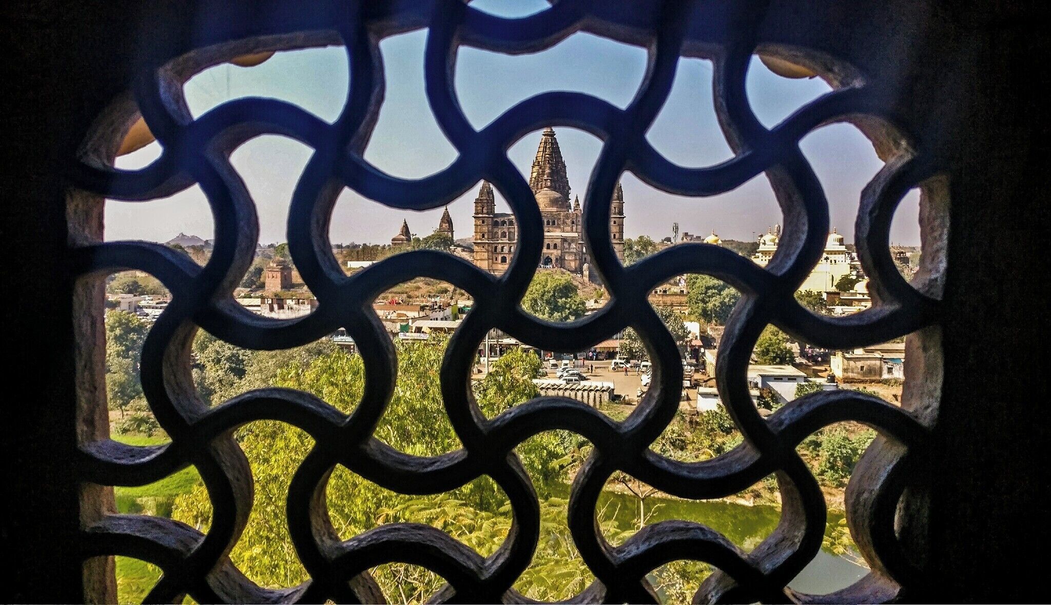 A view of a historic cityscape through a decorative metal gate.