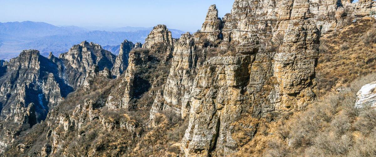 A rugged mountain range with prominent rock formations and sparse vegetation.