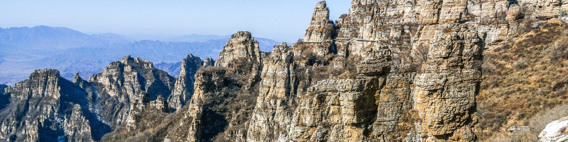 A rugged mountain range with prominent rock formations and sparse vegetation.